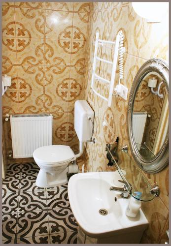 a bathroom with a toilet and a sink and a mirror at White & Quiet Apartment House in Hévíz