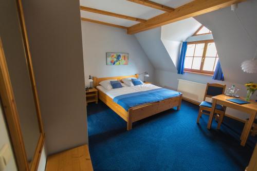 a bedroom with a bed and a table and a desk at Hotel Blaue Blume in Freiberg