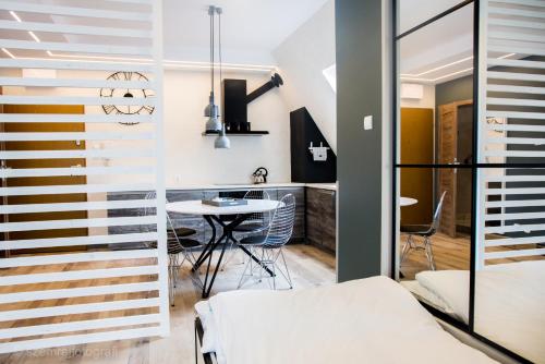 a living room with a table and a dining room at Apartament Happy Place in Giżycko