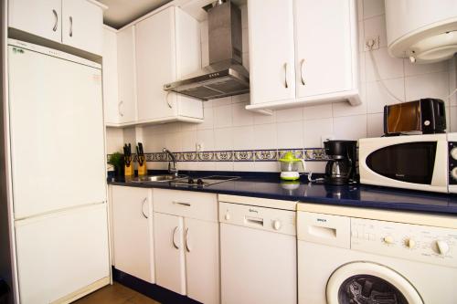 a kitchen with white cabinets and a microwave at Apartamento Cielo 35 in El Puerto de Santa María