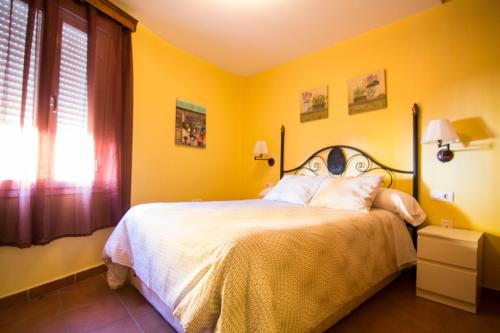 a bedroom with a bed with yellow walls at Apartamento Cielo 35 in El Puerto de Santa María