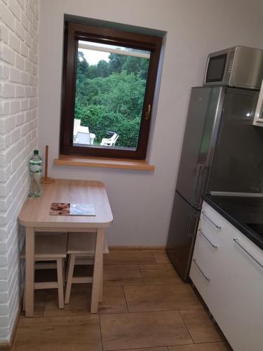 a small kitchen with a table and a window at Domek Kruklanki in Kruklanki