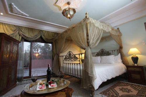 a bedroom with a canopy bed and a table with food at The Red House in Marrakech