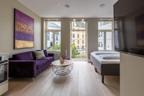 a living room with a purple couch and a table at 2 Døtre Apartments in Bergen