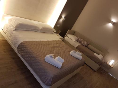 a bedroom with a bed with two towels on it at La Banchina Holiday Rooms in Trani