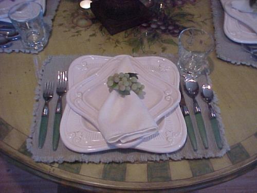 a table with a white plate with a napkin and forks at FLEUR DE LAC EUROPERAN INn in Lake Arrowhead