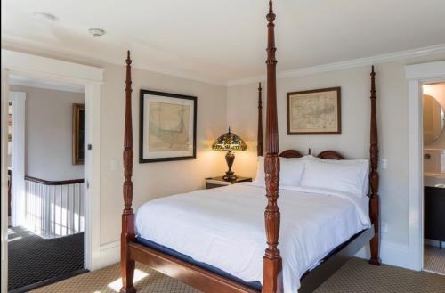 a bedroom with a four poster bed and a staircase at The Clarendon House in Provincetown