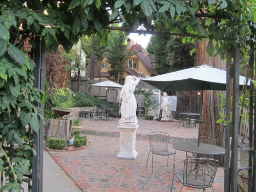 a statue in a courtyard with a table and an umbrella at FLEUR DE LAC EUROPERAN INn in Lake Arrowhead
