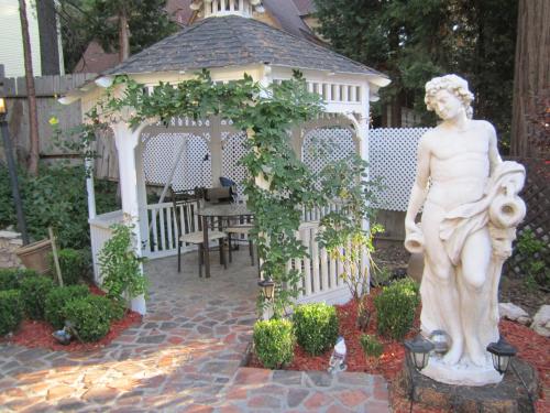 a statue in a garden with a gazebo at FLEUR DE LAC EUROPERAN INn in Lake Arrowhead