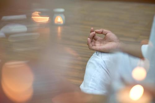 a person sitting on the floor with their hand in the air at The Sintesa Residence Jimbaran in Jimbaran