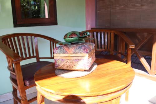 a wooden table with a frog sitting on top of it at Blue Star Bungalows & Cafe in Amed