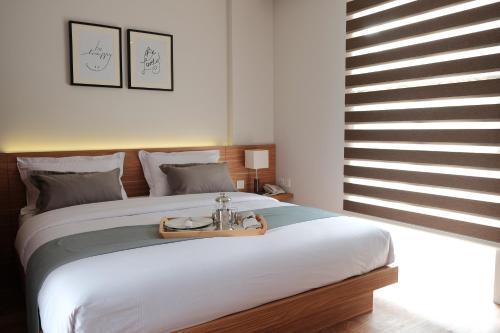 a bedroom with a large bed with a tray on it at FLAT06.Tendean in Jakarta