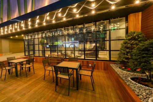 um restaurante com mesas, cadeiras e luzes em Life Style S Hotel em Seul