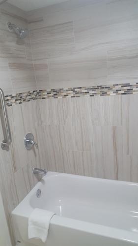 a bathroom with a tub and a sink and a shower at Super 8 by Wyndham Ft Stockton in Fort Stockton