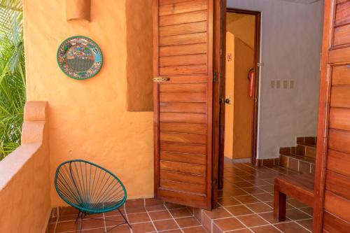 un corridoio con porta in legno e sedia di Villas Miramar a Zihuatanejo