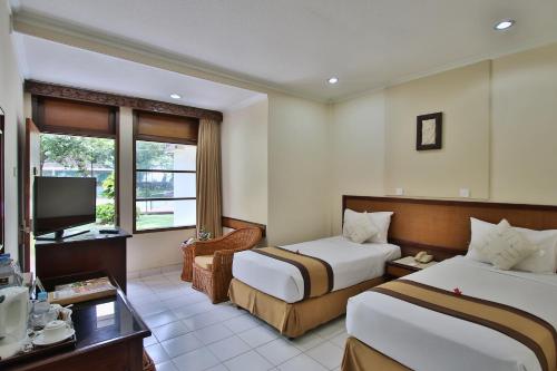 勒吉安The Jayakarta Bali Beach Resort的有两张床和一台电视的酒店房间