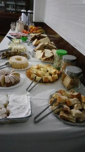 una mesa llena de pasteles y otros alimentos en Hotel Scholze, en Canoinhas