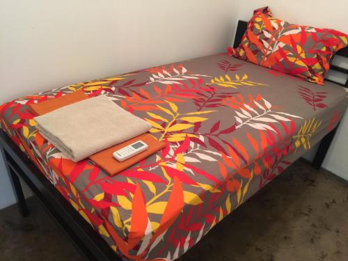 een bed met een deken met een afstandsbediening erop bij 42 Guest House in Bangkok