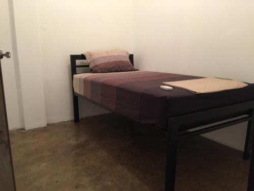 a small bed in a room with a pillow on it at 42 Guest House in Bangkok