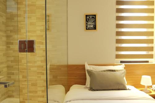 1 dormitorio con 1 cama y ducha acristalada en FLAT06.Tendean en Yakarta