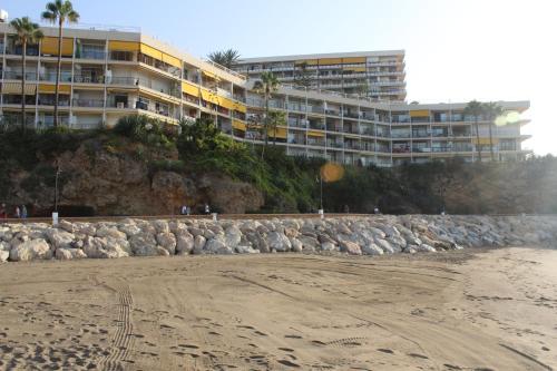 a beach with a beach house and a large building at Apartamentos Castillo de Santa Clara in Torremolinos