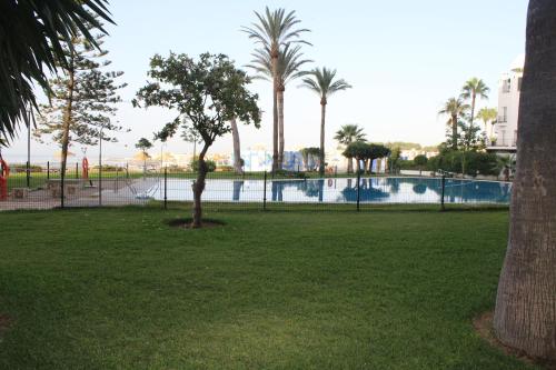 een zwembad in een park met palmbomen bij Castillo Santa Clara in Torremolinos