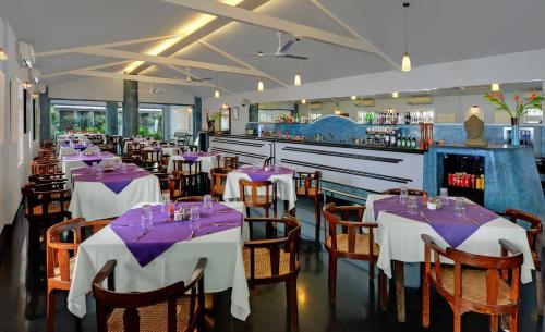 a restaurant with tables and chairs and a bar at Hotel Sunderban Resort & Spa in Pune