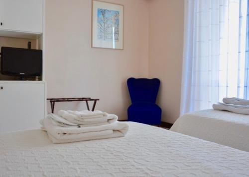 a bedroom with a bed and a blue chair at B&B La Casa di Giò in Casal Palocco