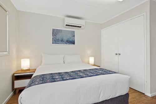 a bedroom with a white bed and two lamps at Discovery Parks - Coogee Beach in Coogee