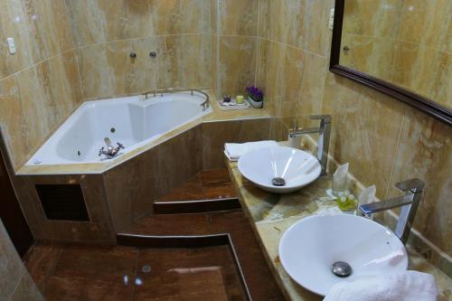 y baño con bañera, lavamanos y bañera. en Hotel Villa de Valverde, en Ica