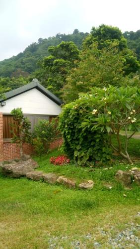 a house with a tree and a bush at Yellow Stone M.V. in Sanyi