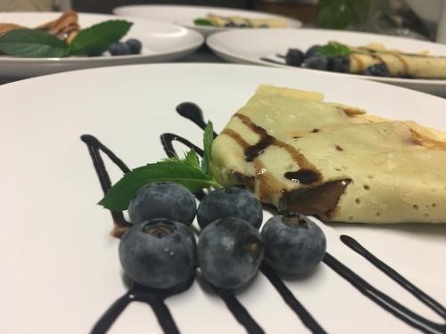 a piece of cheese and blueberries on a plate at B&B Il Piccolo Principe room and breakfast in Bieno