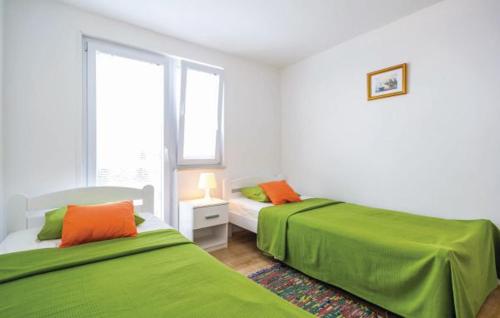 two beds in a white room with green sheets at Holiday Home Rudelic in Lukovo Šugarje
