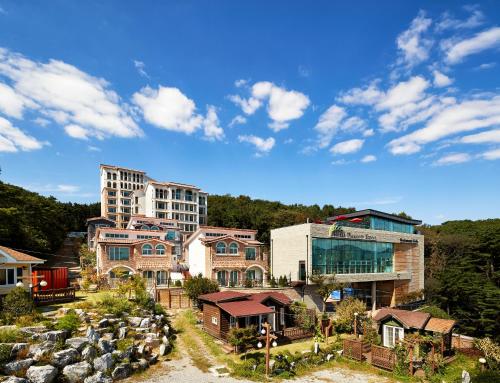 un groupe de maisons avec un bâtiment en arrière-plan dans l'établissement Hotel Thesoom Forest, à Yongin