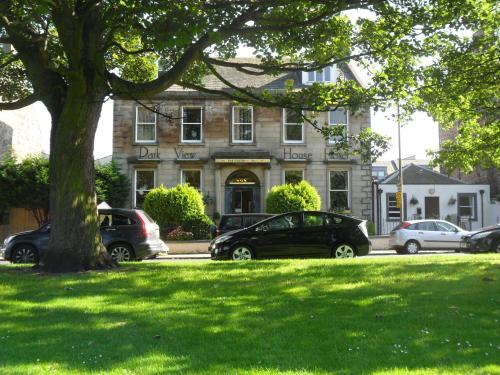 ein Gebäude mit Autos, die vor einem Baum geparkt sind in der Unterkunft Park View House in Edinburgh