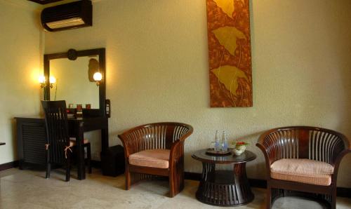 a room with two chairs and a table and a mirror at Hotel Tjampuhan Spa in Ubud