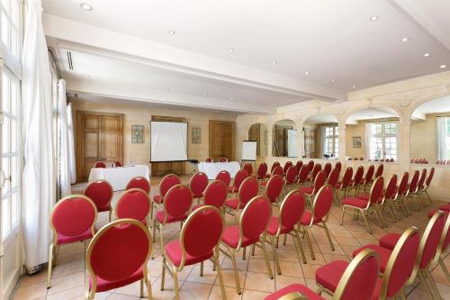 a conference room with red chairs and a screen at Château de Candie in Chambéry
