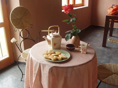 una mesa con una bandeja de galletas y un hervidor de agua. en Hotel Alma de Romero en Carranza