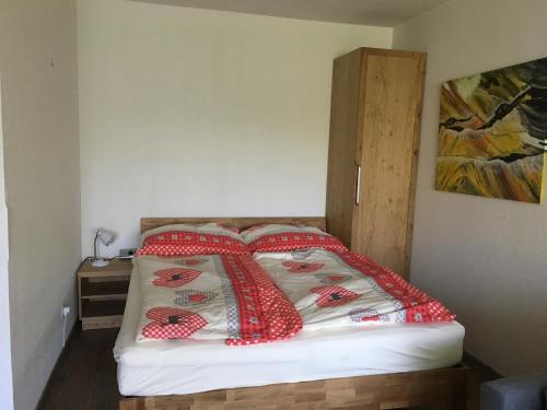 a bedroom with a bed with red and white pillows at Familienurlaub am See in Bodensdorf