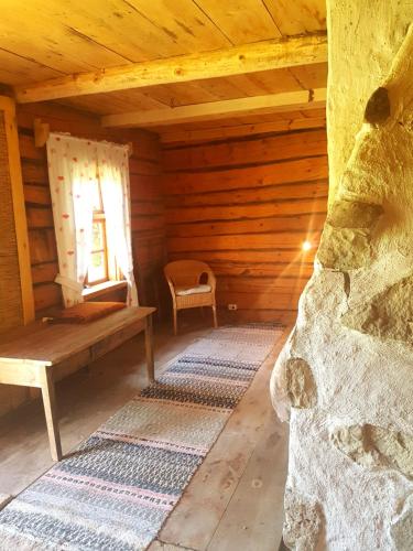 a room with a bench and a window in a log cabin at Paali cottages in Tornimäe