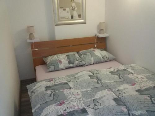 a bedroom with a bed with a comforter on it at Studio apartman Toplica in Daruvar