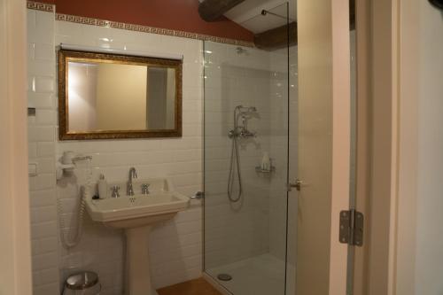 a bathroom with a sink and a shower with a mirror at Vilosell Wine Hotel in El Vilosell