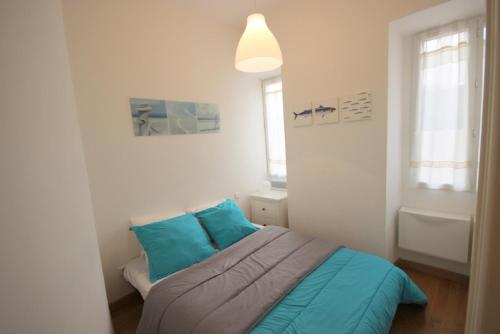 sypialnia z łóżkiem z niebieskimi poduszkami w obiekcie Apartment Palais de France w Nicei
