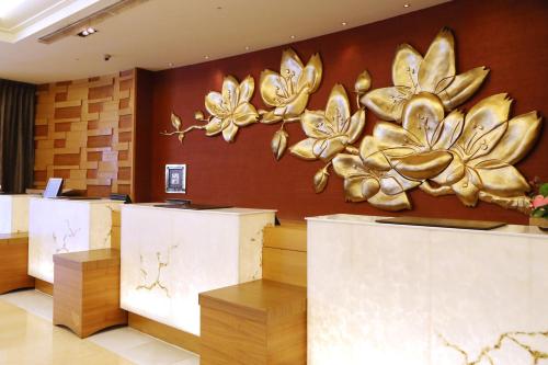 a lobby with gold flowers on the wall at Nice Prince Hotel in Chiayi City
