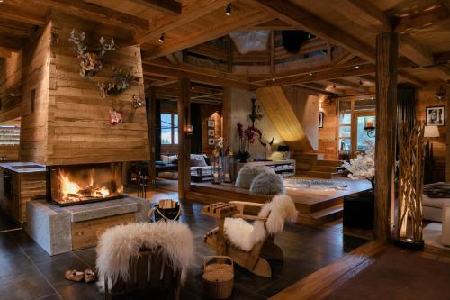 a living room with a fireplace in a log house at La FERME des Lombardes in Saint-Jean-de-Sixt