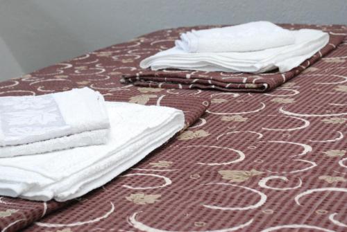 a bed with white towels on top of it at Madzar Apartments in Star Dojran