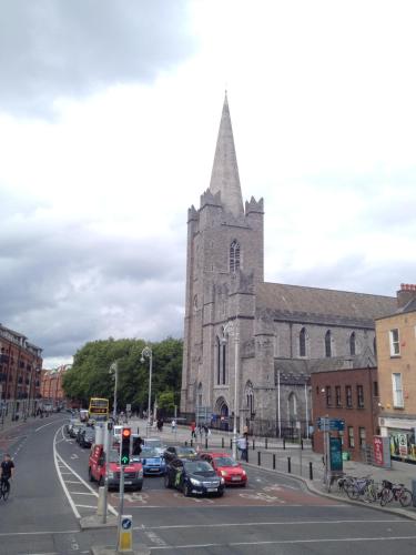 a church with cars parked in front of a street at Acara House B&B in Dublin