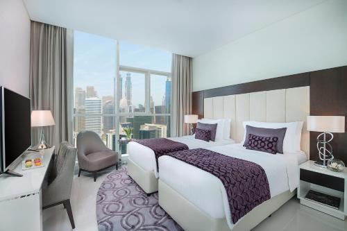 a bedroom with a large bed and a large window at DAMAC Maison Distinction in Dubai
