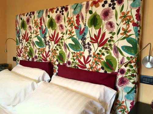 1 dormitorio con 2 camas y pared de flores en Residenza Viviani en Sant'Agnello