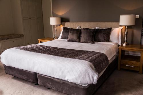 a large bed in a bedroom with two lamps at Simmers Serviced Apartments in Williamstown